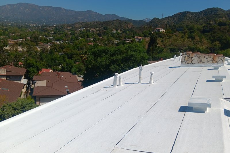 White low-slope roof field with penetrations and seams