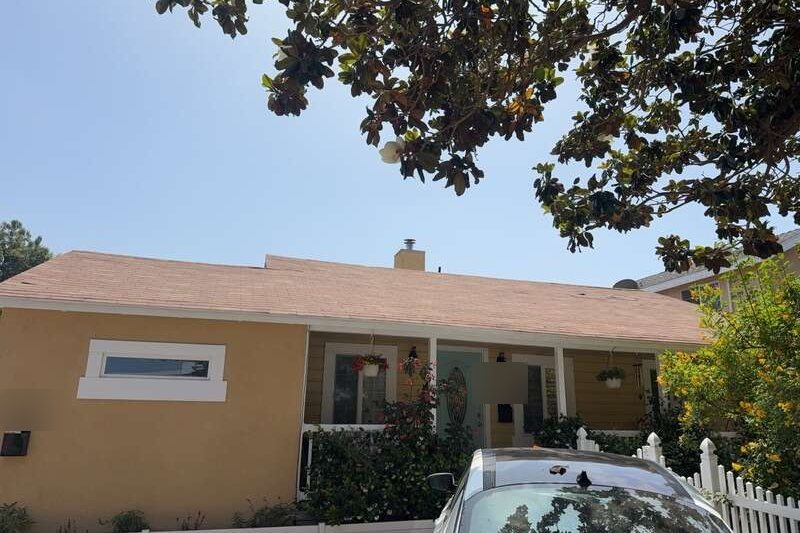 Residential asphalt-shingle roof meeting an exterior wall
