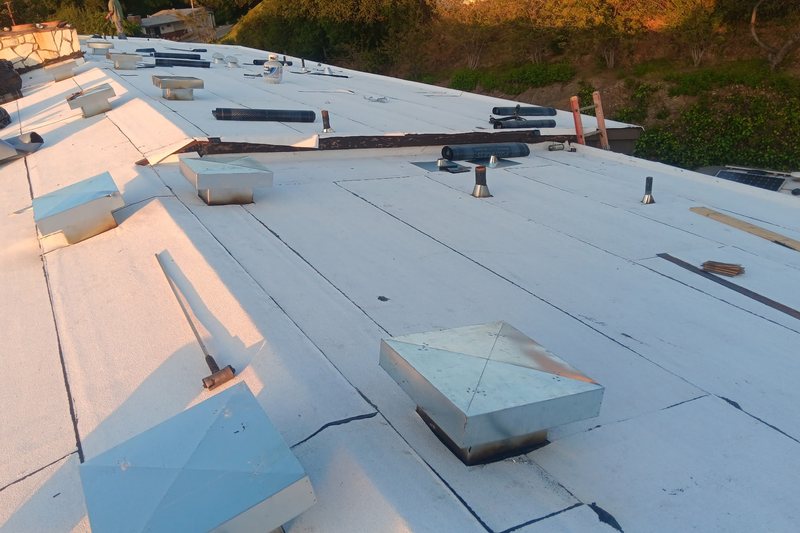 White low-slope roof with raised curbs and rooftop components